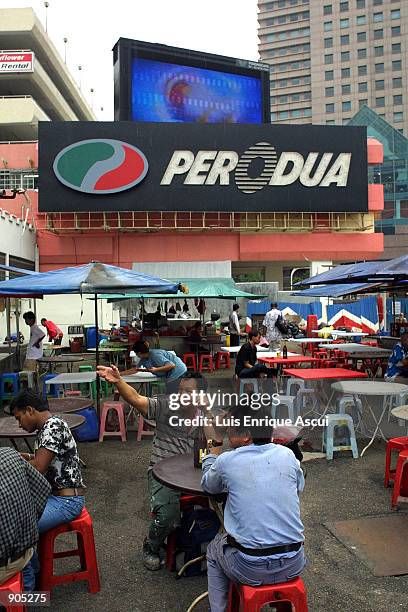 Big Screens above a street food market play movie trailers March 30, 2002 in Johor Barhu south East of Kuala Lumpur in Singapore. Cinema goers in...