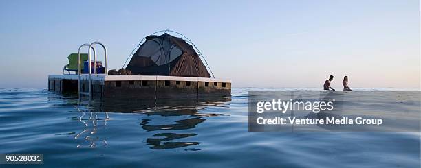 couple camping on a floating platform in the ocean. - carpinteria stock pictures, royalty-free photos & images