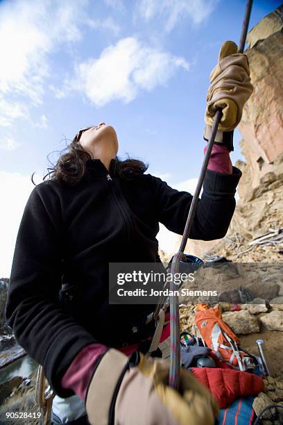 a belayer taking up the slack for a lead rock climber. - messa in sicurezza foto e immagini stock