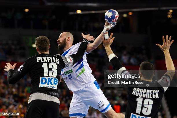 Vid Kavticnik of Slovenia is challenged by Hendrik Pekeler of Germany and Bastian Roscheck of Germany during the Men's Handball European Championship...