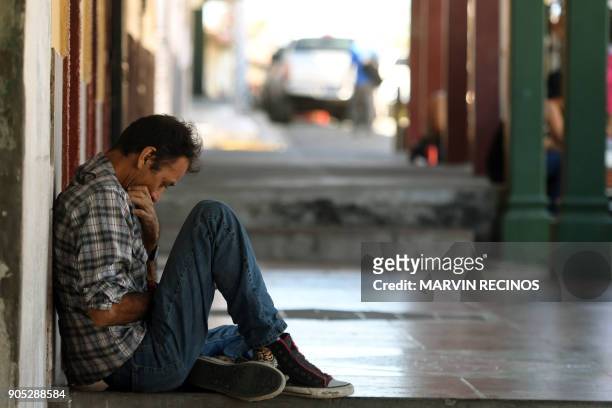 Man uses his celphone as he rests outside his home in San Isidro municipality, Cabanas department, 70 km northeast of San Salvador on January 13,...
