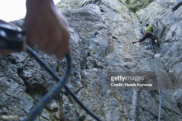 ecuadorian national climbing champion climbing son of jesus (5.10c) at one of seattle's local crags. - messa in sicurezza foto e immagini stock