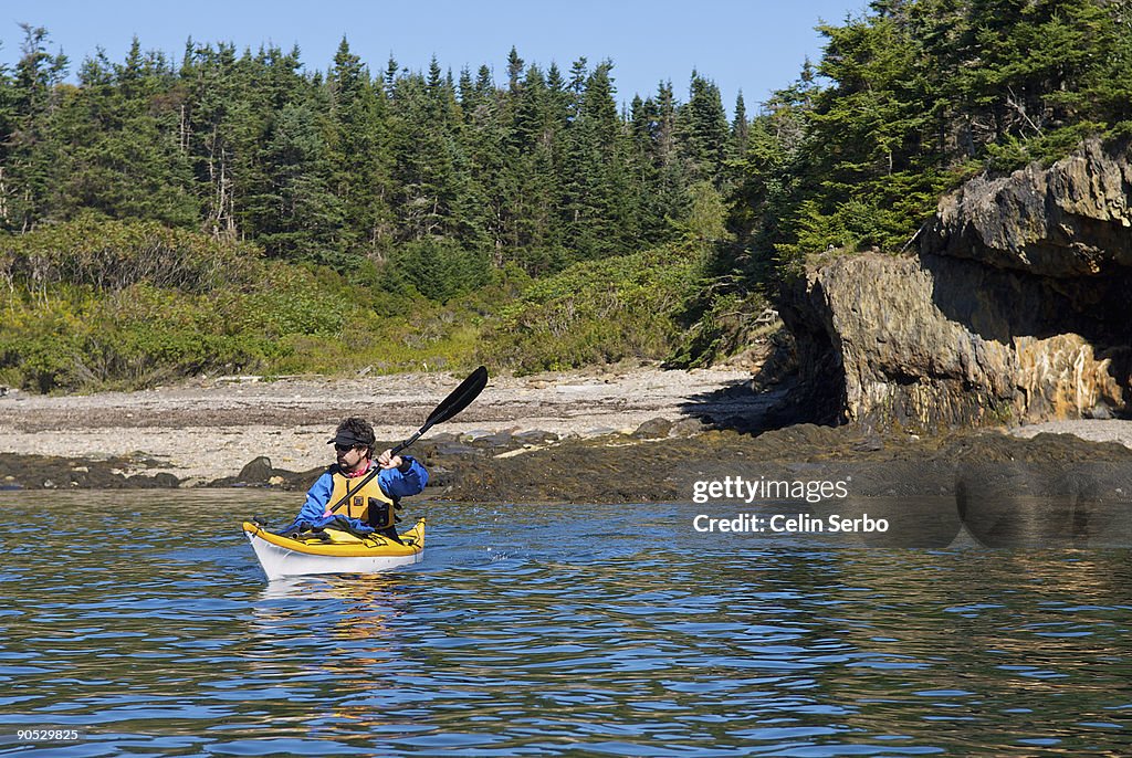 A man sea kayaking on the Maine coast.
