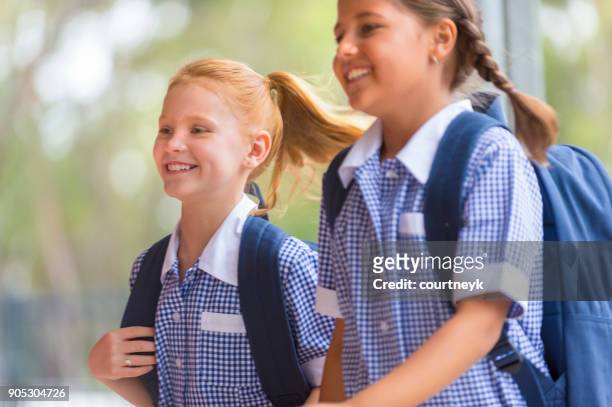 schoolgirls in uniform with back pack. - primary school children in uniform stock pictures, royalty-free photos & images