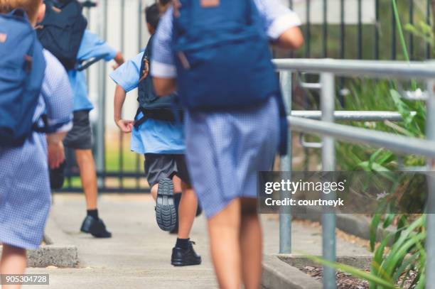 school children walking away. - primary school children in uniform stock pictures, royalty-free photos & images