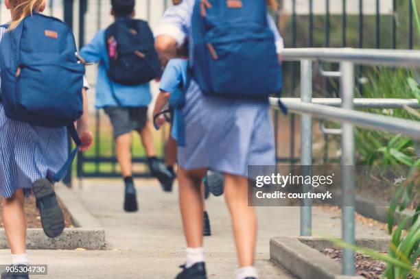 school children walking away. - school stock pictures, royalty-free photos & images