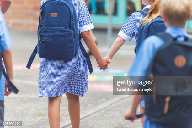 schoolkinderen weglopen. - schooluniform stockfoto's en -beelden