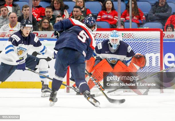 Olli Juolevi and Ukko-Pekka Luukkonen of Finland defend the Finland net against an incoming shot from Martin Bodák of Slovakia during the second...