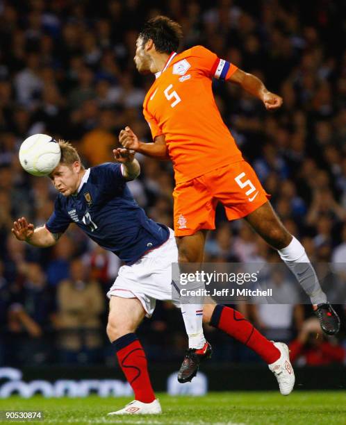 Kris Commons of Scotland is challenged by Giovanni van Bronckhorst of Netherlands during the FIFA 2010 World Cup Group 9 Qualifier match beteween...