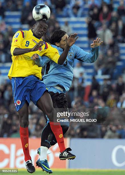 Colombia's midefielder Gustavo Adrian Ramos and Uruguay's defender Martin Caceres jump for a header during a FIFA World Cup South Africa-2010...