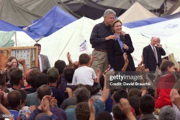 President Bill Clinton hugs his wife Hillary as they listen to the applause of ethnic Albanian refugees June 22, 1999 at the Stenkovec refugee camp....