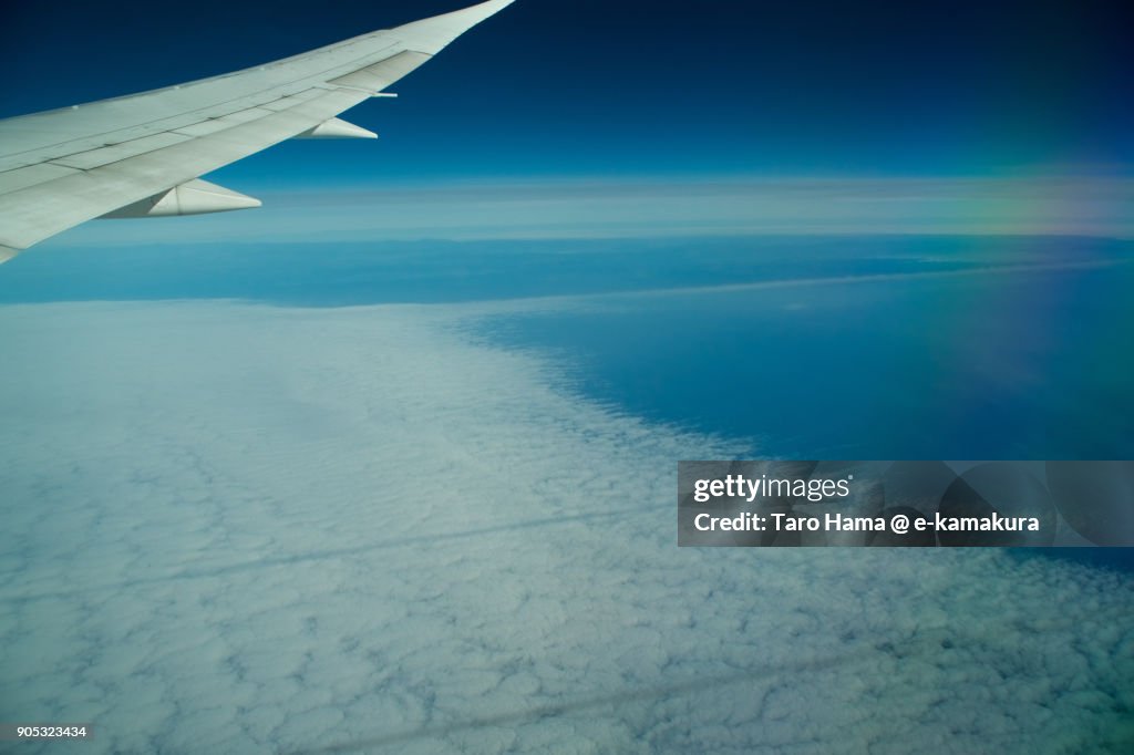 Two vapor trails on clouds on Pacific Ocean in California in USA daytime aerial view from airplane