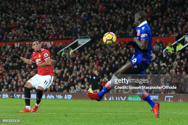 Anthony Martial of Manchester United puts the ball past Kurt Zouma of Stoke City to score their 2nd goal during the Premier League match between...