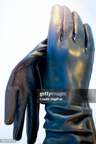 black leather gloves one holding the other one - paire de gants noirs photos et images de collection