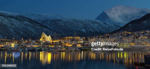 view on illuminated city of tromso with modern cathedral at arctic night - tromso stock pictures, royalty-free photos & images