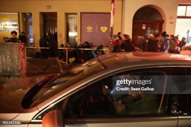 Sneaker fans, who said they did not mind being photographed, keep warm in a car while waiting with others bundled against the cold in front of the...