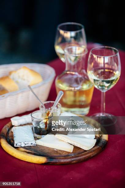 cheese board served with white wine in bergamo, italy - bergamo stock photos et images de collection