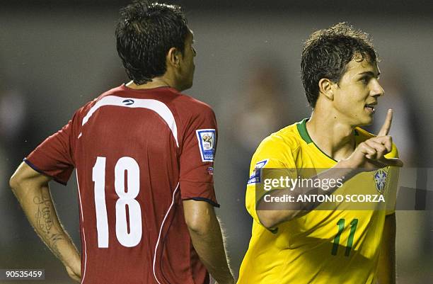 Brazil's Nilmar celebrates his goal as Chile's Gonzalo Jara reacts during their FIFA World Cup South Africa-2010 qualifier football match at Pituacu...
