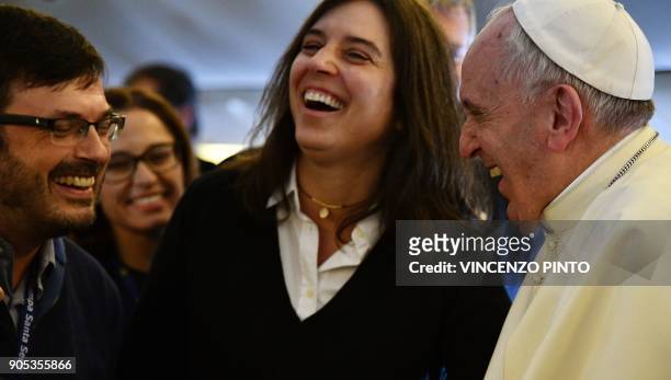 Pope Francis smiles as he welcomes journalists on board the plane on the way to Santiago at the start of his seven-day trip to Chile and Peru, on...