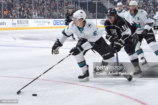 Justin Braun of the San Jose Sharks handles the puck against Anze Kopitar of the Los Angeles Kings at STAPLES Center on January 15, 2018 in Los...