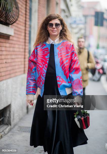 Sara Battaglia wearing blue red jacket, black high waisted velvet skirt, black red striped bag is seen outside No21 during Milan Men's Fashion Week...