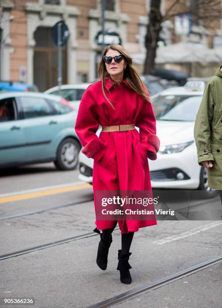 Anna dello Russo wearing red coat with brown belt, black ankle boots is seen outside Fendi during Milan Men's Fashion Week Fall/Winter 2018/19 on...