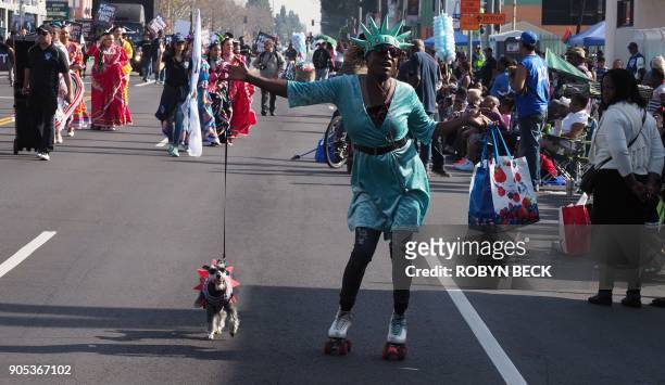 Woman dressed as Lady Liberty to promote Liberty Tax Service roller skates with her dog during the 33rd annual Kingdom Day Parade honoring Dr. Martin...