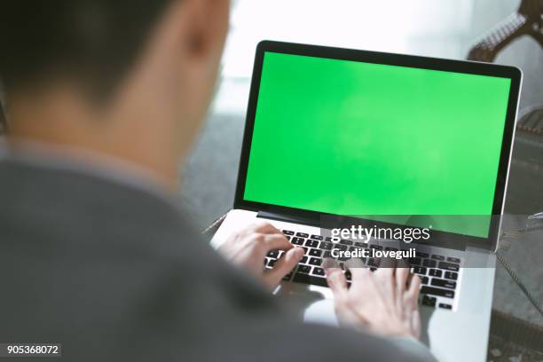 hombre joven asiático utilizando el ordenador portátil - croma verde fotografías e imágenes de stock