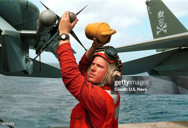 Michael Wilkerson, of Virginia Beach, VA loads an AIM-9 Sidewinder Air to Air Missile on an F-14 "Tomcat" jet on board the flight deck of the USS...