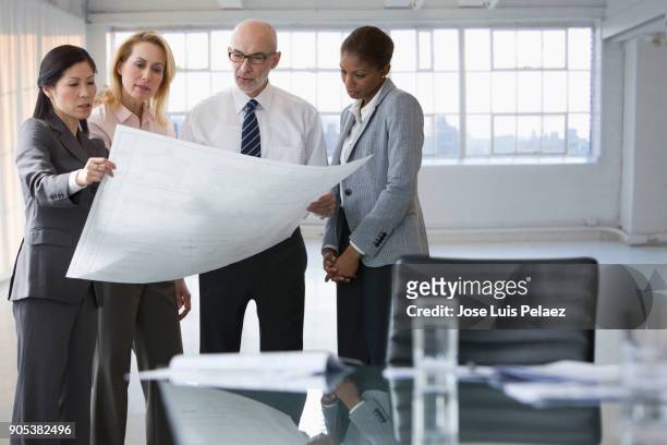 architect reviewing plans with project manager and team - senior man grey long hair stock pictures, royalty-free photos & images