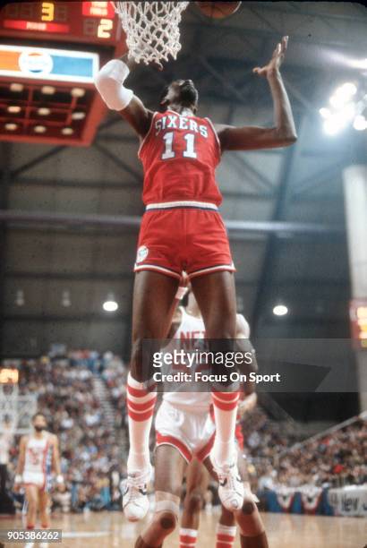 Caldwell Jones of the Philadelphia 76ers go up to grab a rebound in front of George Johnson of the New Jersey Nets during an NBA basketball game...