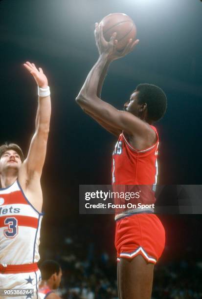 Caldwell Jones of the Philadelphia 76ers shoots over Jeff Ruland of the Washington Bullets during an NBA basketball game circa 1981 at the Capital...