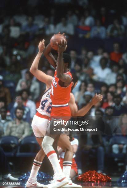 Caldwell Jones of the Philadelphia 76ers looks to pass the ball over Greg Ballard of the Washington Bullets during an NBA basketball game circa 1982...