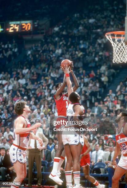 Caldwell Jones of the Philadelphia 76ers goes up to shoot over Rick Mahorn of the Washington Bullets during an NBA basketball game circa 1982 at the...