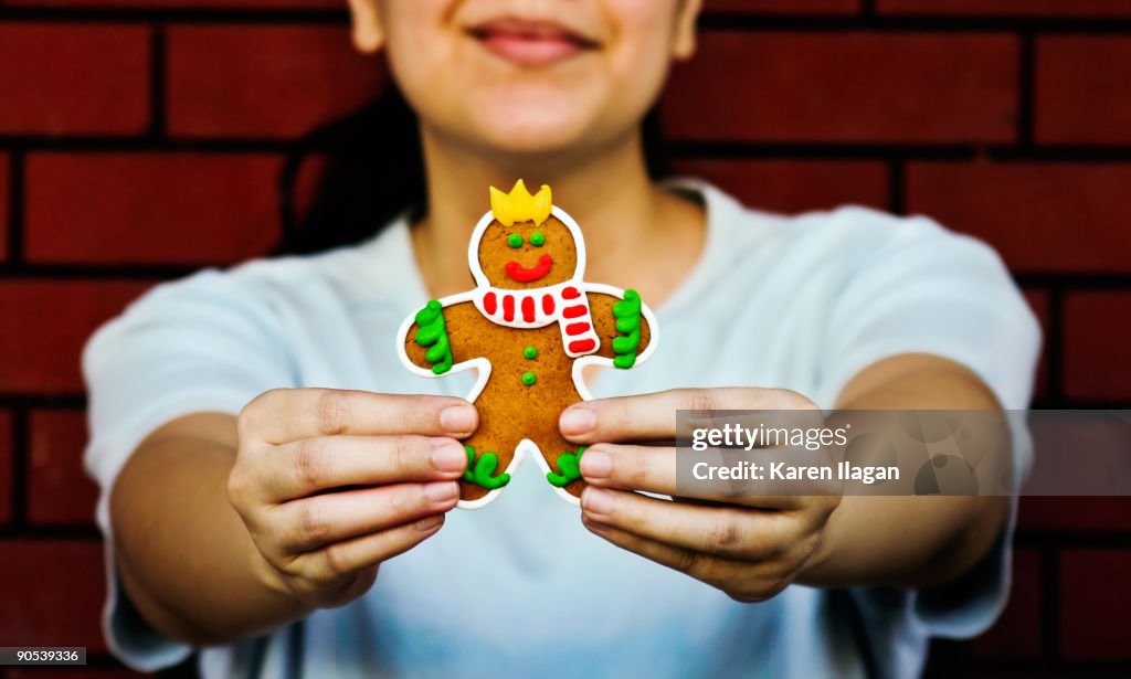 Woman holding up smiling gingerbread man