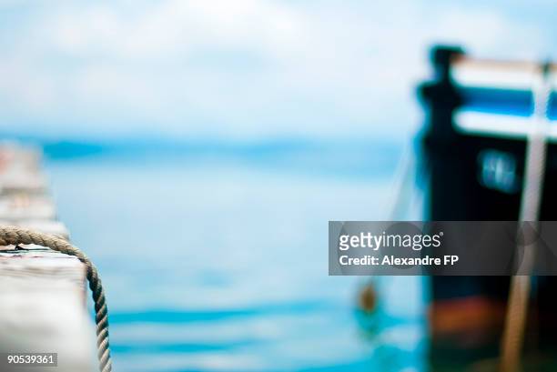rope and distant boat - alexandre moors stock pictures, royalty-free photos & images