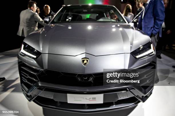 Attendees stand around the Automobili Lamborghini SpA Urus sport utility vehicle as it sits on stage during the 2018 North American International...
