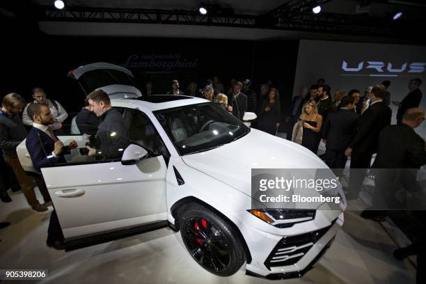 Attendees stand around the Automobili Lamborghini SpA Urus vehicle as it is unveiled at an event during the 2018 North American International Auto...