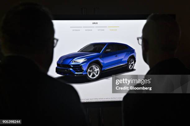 Attendees look over a video display of an Automobili Lamborghini SpA Urus sport utility vehicle during an event the 2018 North American International...