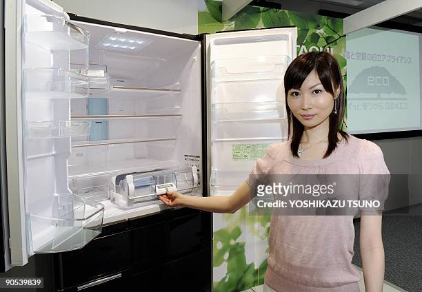 Model displays Japanese electronics giant Hitachi's new energy saving refrigerator at the company's headquarters in Tokyo on September 10, 2009. This...