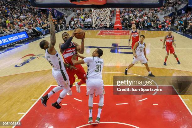 Washington Wizards guard John Wall scores against Milwaukee Bucks guard Eric Bledsoe and forward John Henson on January 15, 2018 at the Capital One...