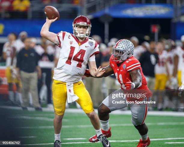 Trojans quarterback Sam Darnold throws the ball as he is about to be hit by Ohio State Buckeyes defensive end Jalyn Holmes during the Cotton Bowl...