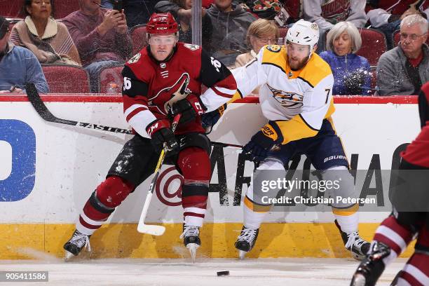 Christian Fischer of the Arizona Coyotes and Yannick Weber of the Nashville Predators battle for a loose puck during the second period of the NHL...