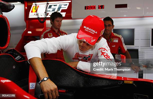 New Ferrari driver Giancarlo Fisichella of Italy familiarises himself with his car in the team garage during previews to the Italian Formula One...