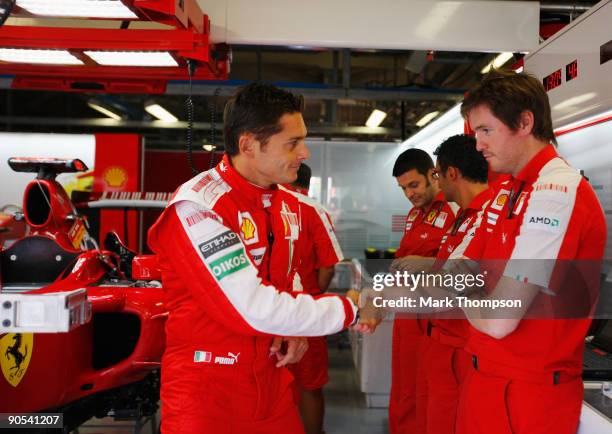 New Ferrari driver Giancarlo Fisichella of Italy shakes hand with his race engineer Rob Smedley in the team garage during previews to the Italian...