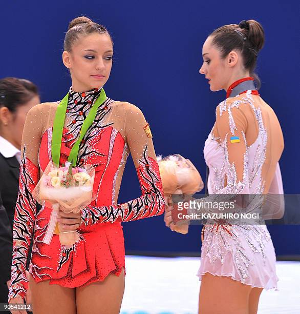 Champion Evgenia Kanaeva of Russia looks at second-place Anna Bessonova of Ukraine prior to the awards ceremony for the ribbon event apparatus final...