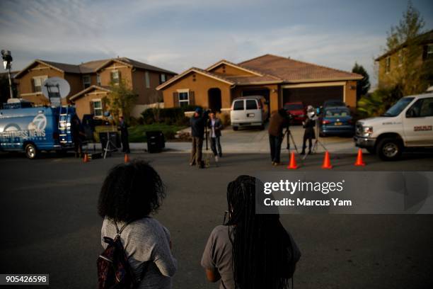 Neighbors stand outside the day after a Perris husband and wife are in custody on suspicion of torture and child abuse at a home on 100 Block of Muir...