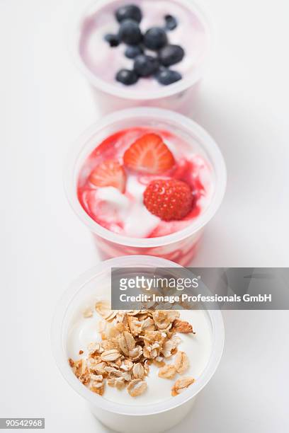 three yoghurts with berries and with cereal, close up - yoghurt pot stock pictures, royalty-free photos & images