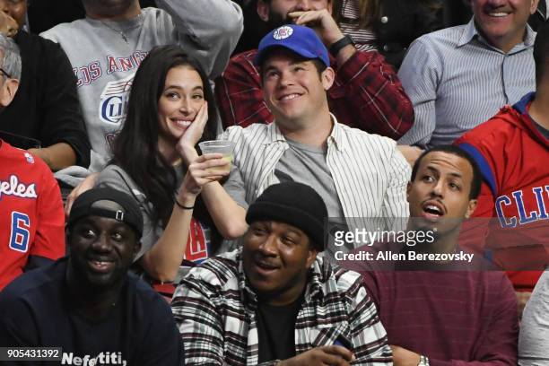 Actor Adam Devine and Chloe Bridges attend a basketball game between the Los Angeles Clippers and the Houston Rockets at Staples Center on January...