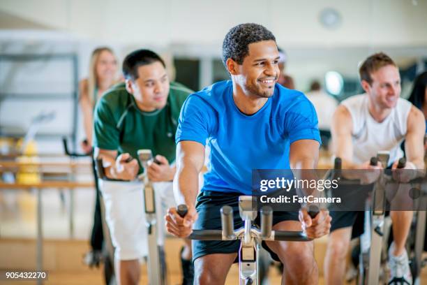 riding exercise bikes - group gym class stock pictures, royalty-free photos & images